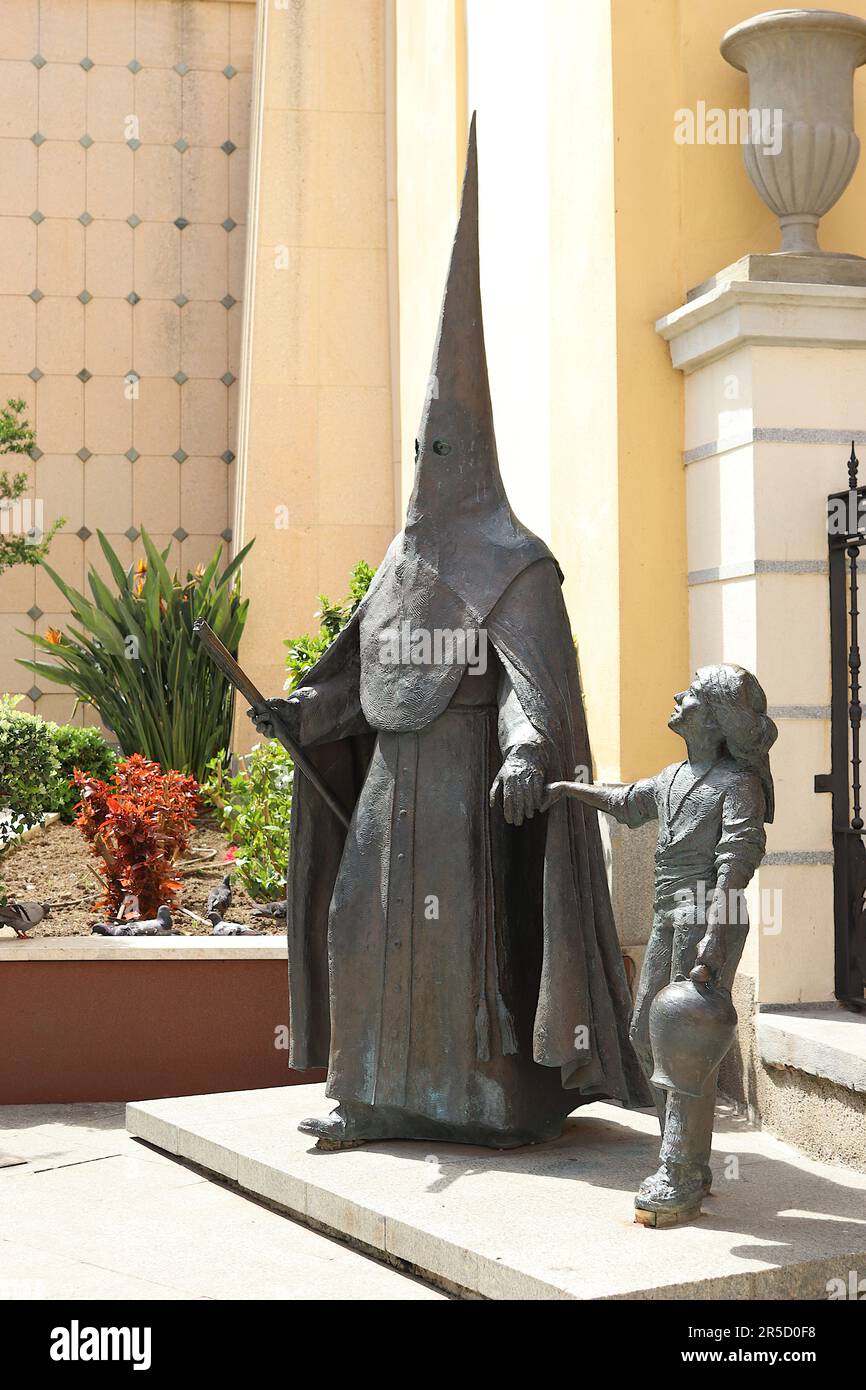 Statue de style baroque d'un penitent à capuchon tenant la main de son petit fils représentant un monument de la semaine Sainte à Ceuta, Espagne, avril 2023. Banque D'Images