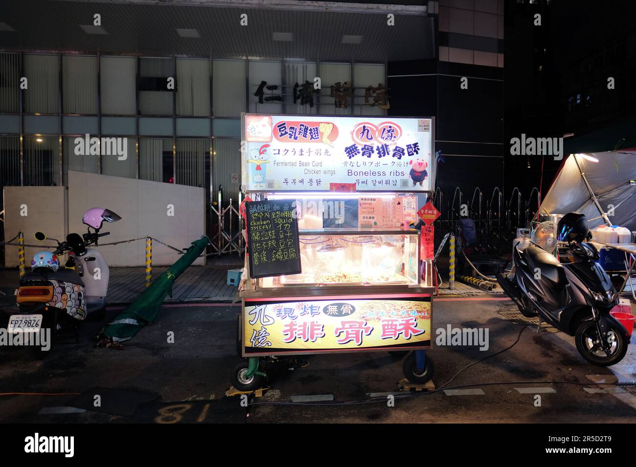La caillé de haricots fermentés, les ailes de poulet, les calmars et les côtes désossées se tiennent au marché de nuit touristique de Huaxi Street à Taipei, Taïwan; chariot alimentaire local de rue. Banque D'Images