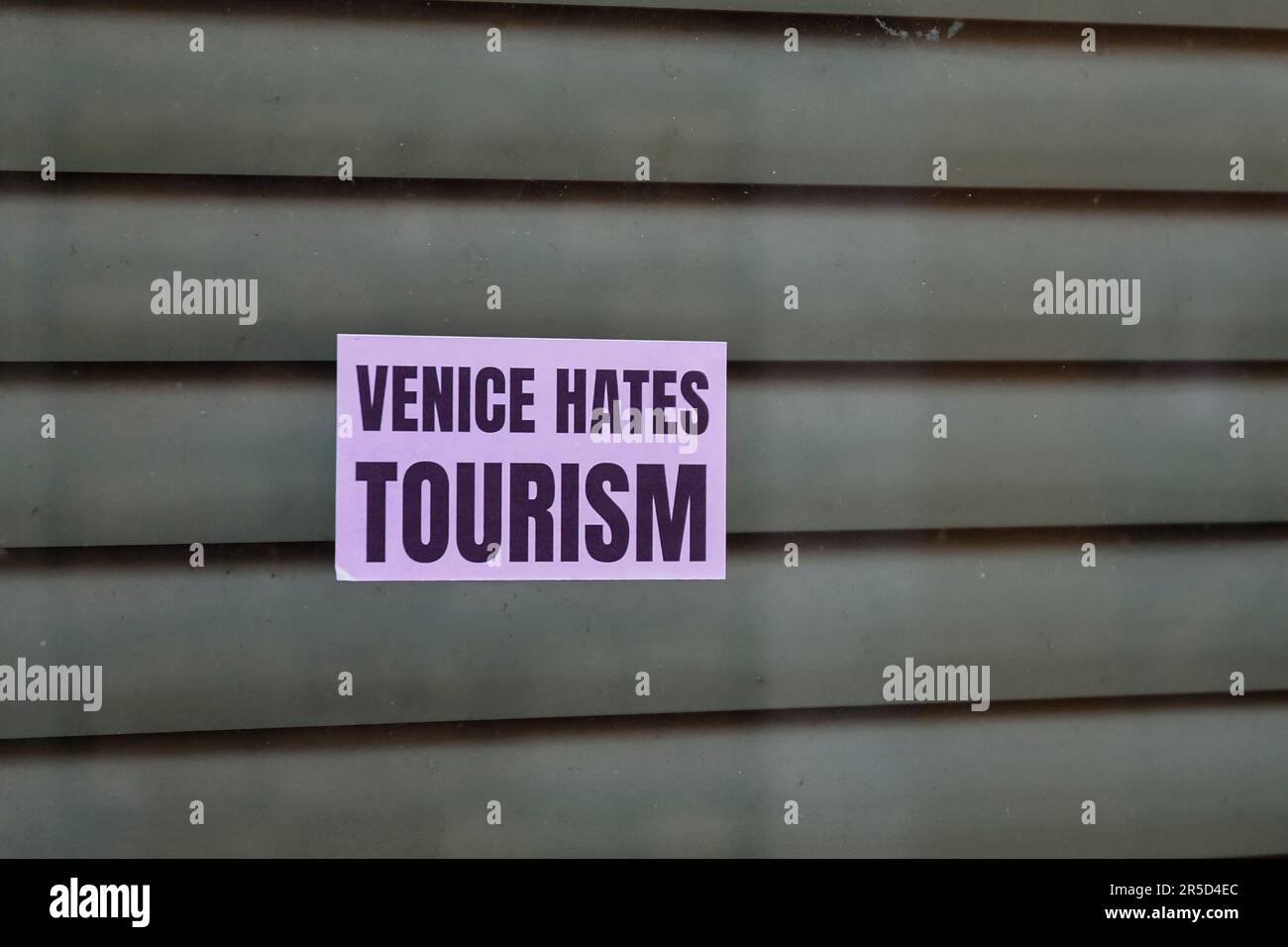 Gros plan d'un panneau de protestation sur un magasin de fermeture qui dit "Venise hait le tourisme", le tourisme de masse est en effet un problème majeur pour Venise, Vénétie, Italie Banque D'Images