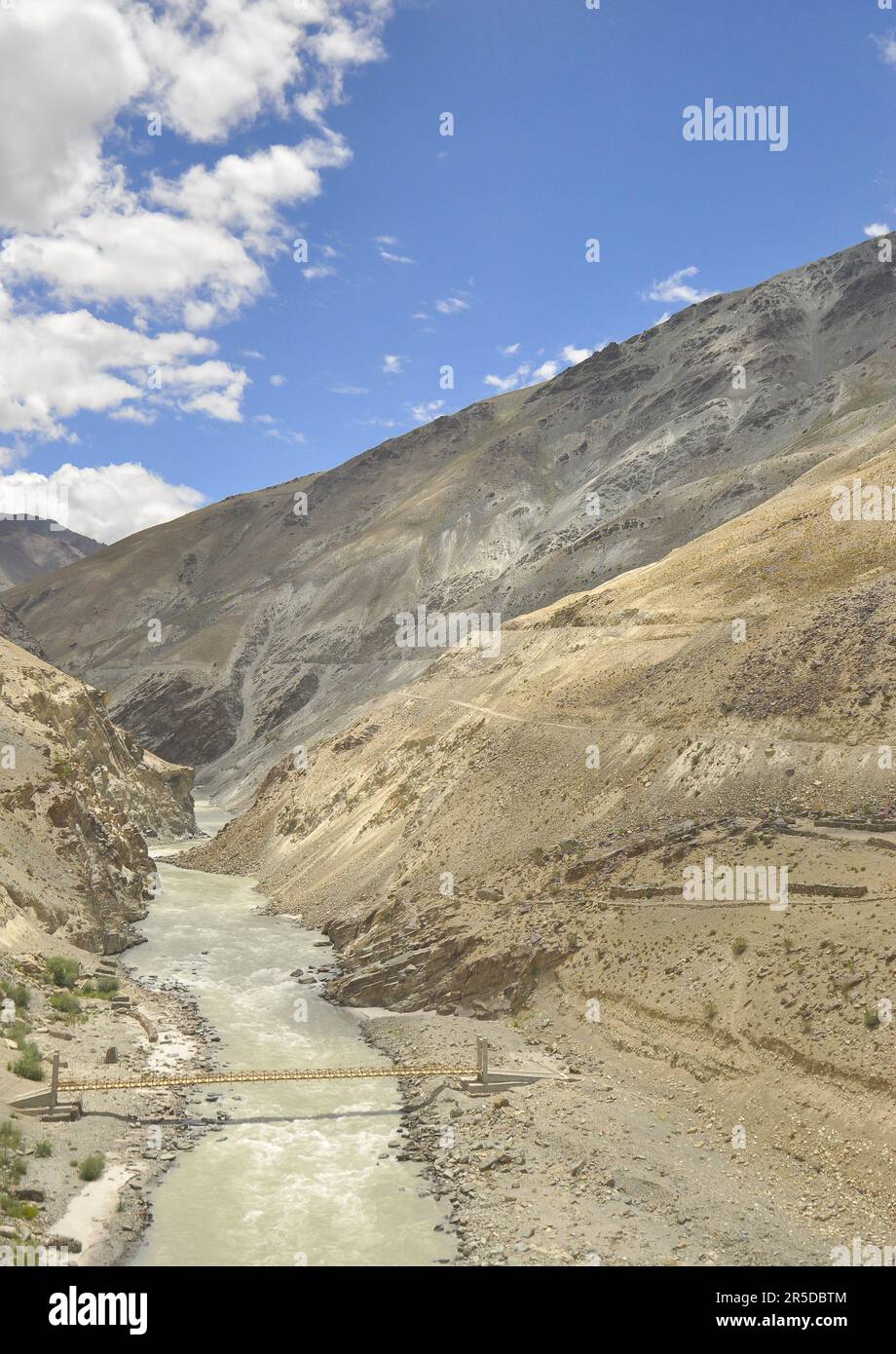 Belle vue d'un pont suspendu en bois sur la rivière entre les montagnes sèches au Ladakh, EN INDE. Banque D'Images