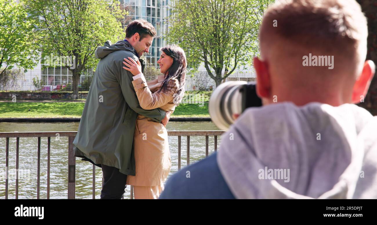 Homme Paparazzi photographe capturant Une photo suspecte d'un couple marchant ensemble Banque D'Images