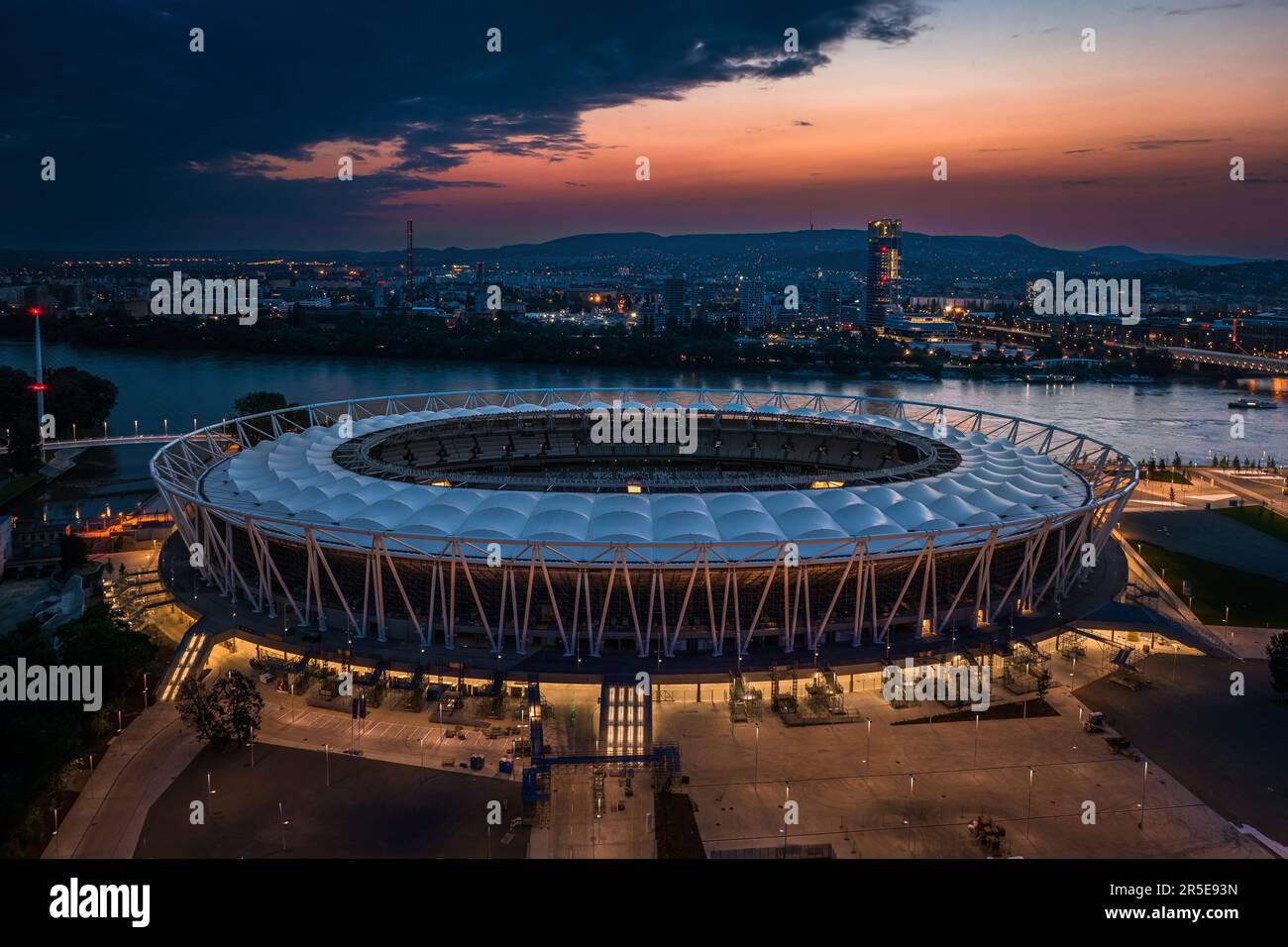 Budapest, Hongrie - vue aérienne du Centre National d'Athlétisme illuminé sur la rive du Danube avec pont Rakoczi et gratte-ciel MOL Campus Banque D'Images