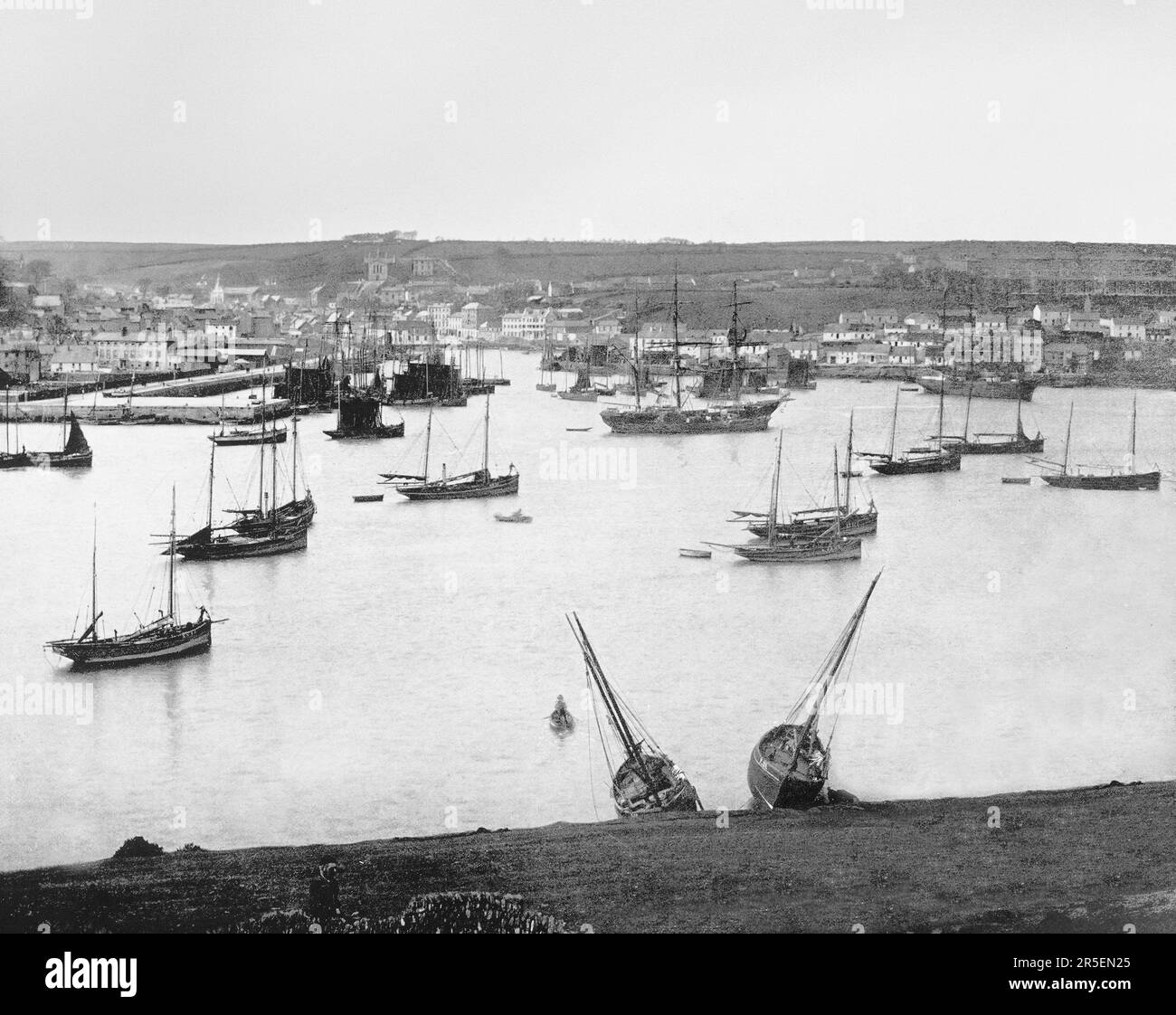 Une vue de la fin du 19th siècle de la navigation copieuse dans le port de Kinsale, un port historique et ville de pêche dans le comté de Cork, en Irlande, l'emplacement de plusieurs batailles. Le plus important est en 1601, lorsqu'une expédition militaire espagnole y a atterri pour établir un lien avec les forces rebelles irlandaises et attaquer l'Angleterre à travers l'Irlande. En conséquence, la bataille de Kinsale a eu lieu à la fin de la guerre de neuf ans au cours de laquelle les forces anglaises ont vaincu la force rebelle irlandaise, dirigée par Hugh O'Neill, comte de Tyrone en 2nd et Red Hugh O'Donnell, deux princes gaéliques d'Ulster. Banque D'Images