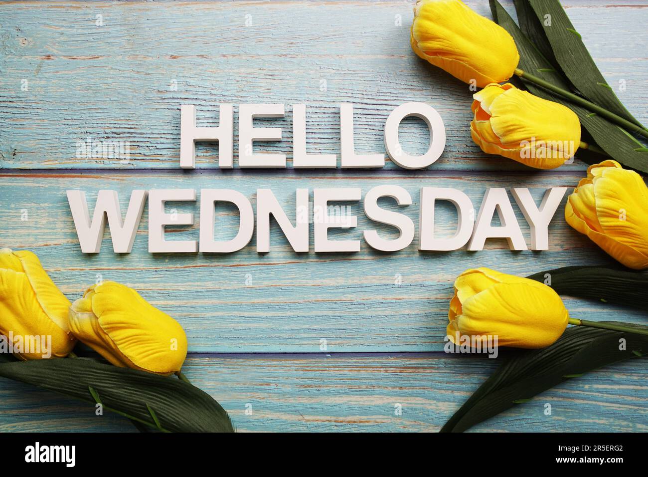 Bonjour alphabet de mercredi avec fleur de tulipe jaune sur fond de bois Banque D'Images