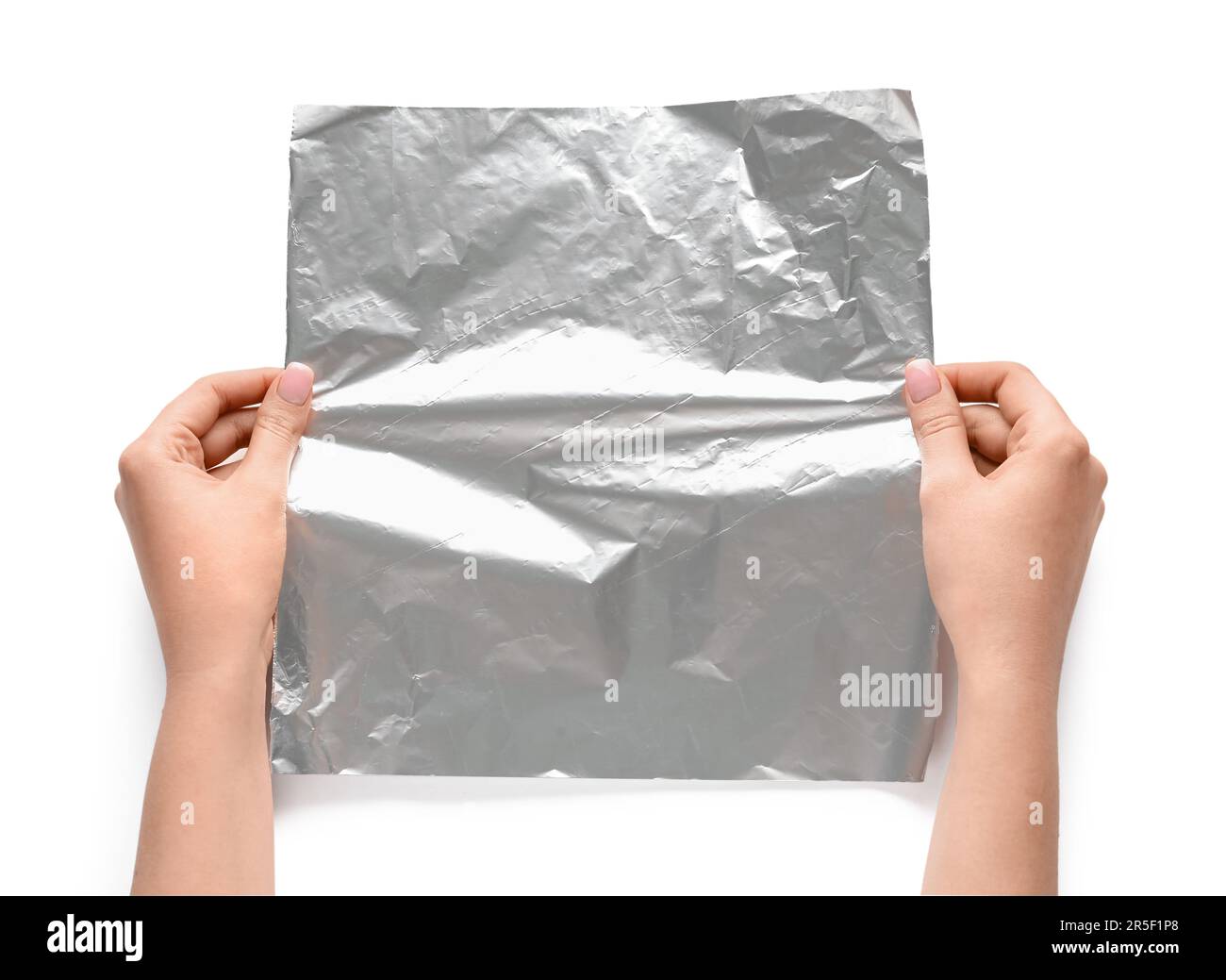 Mains de femmes avec feuille d'aluminium sur fond blanc, gros plan Banque D'Images