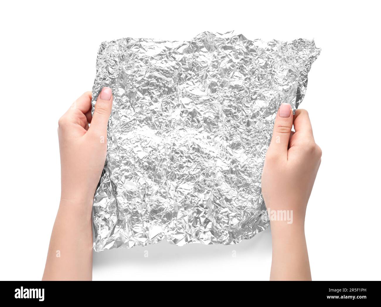 Mains de femmes avec feuille d'aluminium froissé sur fond blanc, gros plan Banque D'Images