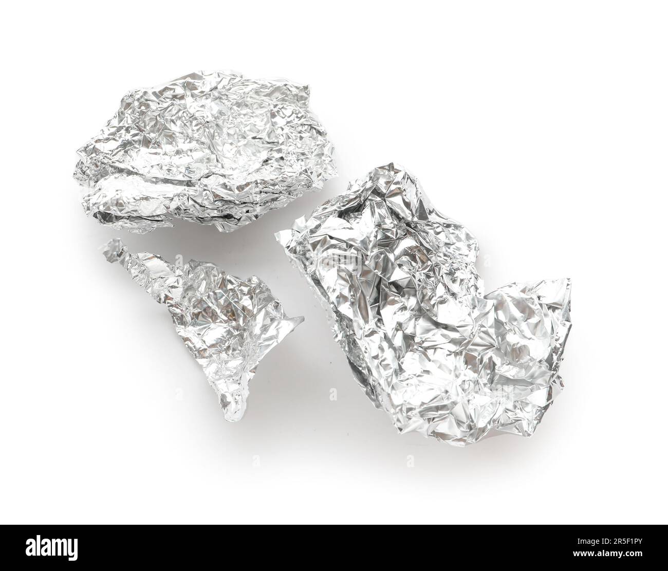 Morceaux de papier aluminium froissé sur fond blanc Banque D'Images