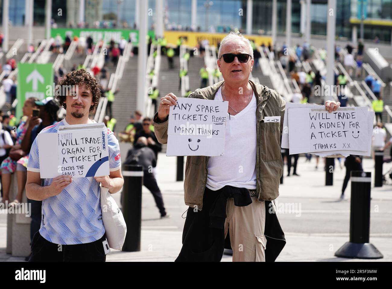 Les personnes à la recherche de billets de rechange ont des panneaux à l'extérieur du stade Wembley alors que les fans arrivent avant la finale de la coupe Emirates FA entre Manchester City et Manchester United. Date de la photo: Samedi 3 juin 2023. Banque D'Images