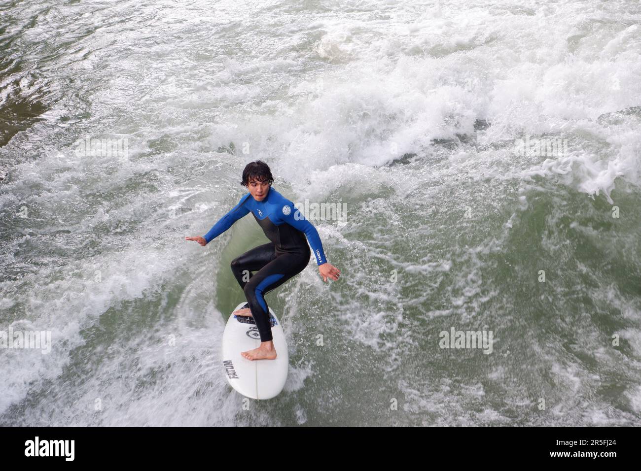 Surfeurs à la vague artificielle Eisbach sur la rivière Isar qui coule à travers le parc Englischer Garten (jardins anglais) à Munich en Allemagne Banque D'Images