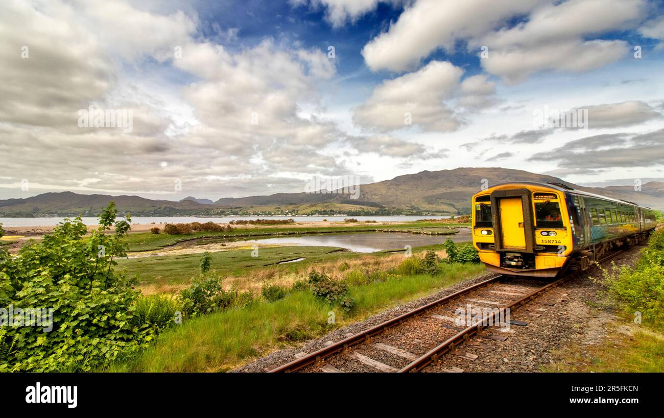 Strathcarron Scotland train ScotRail arrivant à la gare d'Attadale avec Lochcarron Village et Loch au loin Banque D'Images