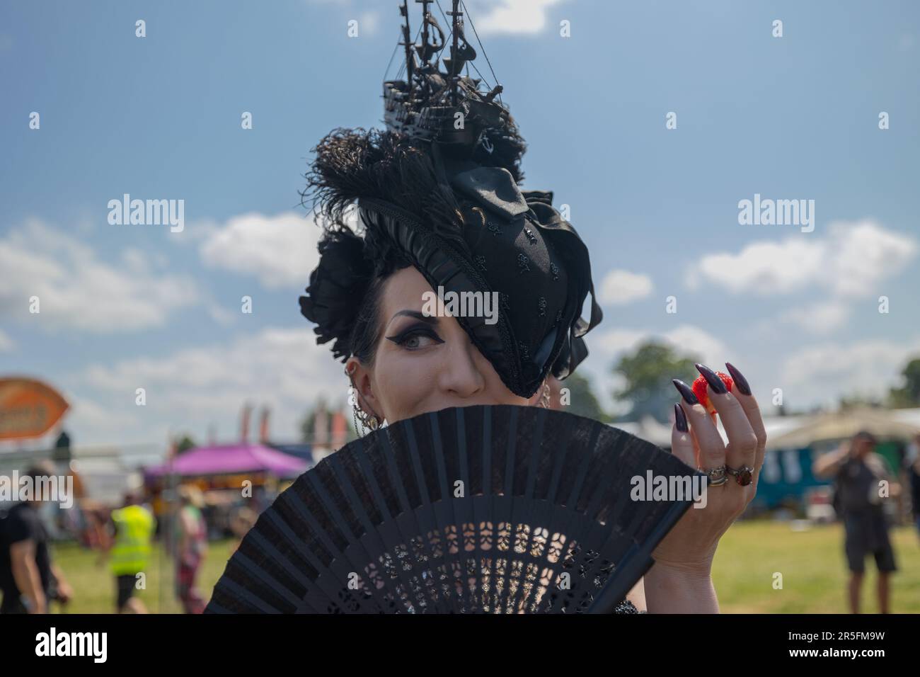 Cambridge, Royaume-Uni. 3 juin 2023. Un festivalier dans un costume gothique élaboré et un casque sur le thème du bateau pose avec un fan noir à Strawberry Fair, Cambridge. Le festival annuel gratuit des arts et de la musique, qui a lieu à Midsummer Common, célèbre la créativité locale, la culture alternative et l'esprit communautaire. La Foire aux fraises de 2023. Penelope Barritt/Alamy Live News Banque D'Images
