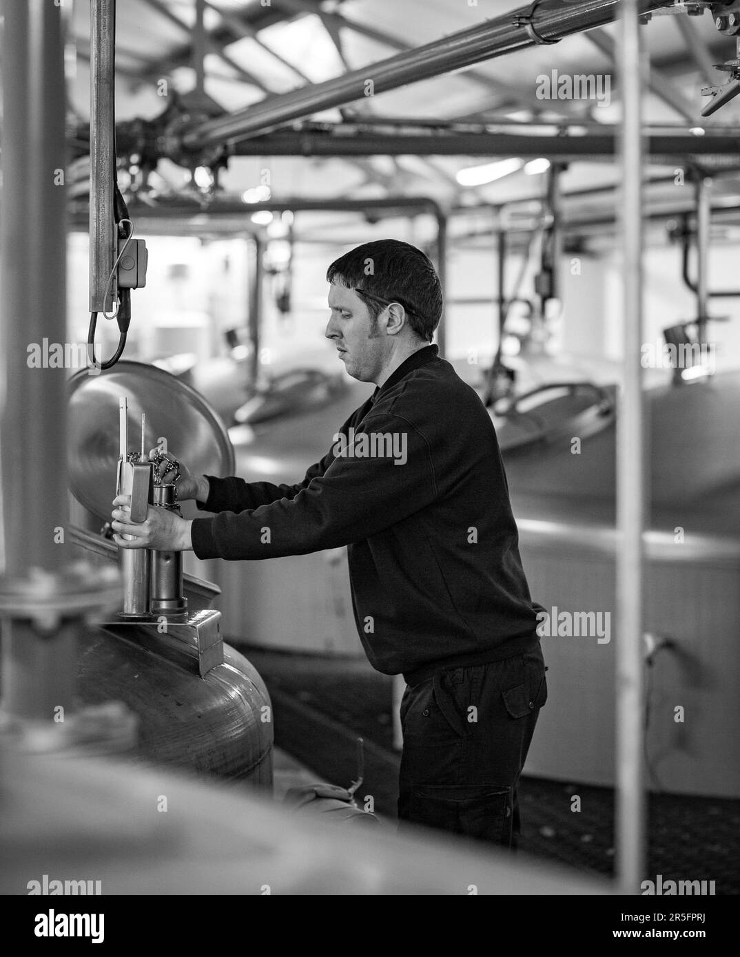 Un travailleur de la distillerie qui vérifie le processus de fermentation à la distillerie de whisky Tamnavulin, Ballindalloch, Banffshire, Écosse, Banque D'Images
