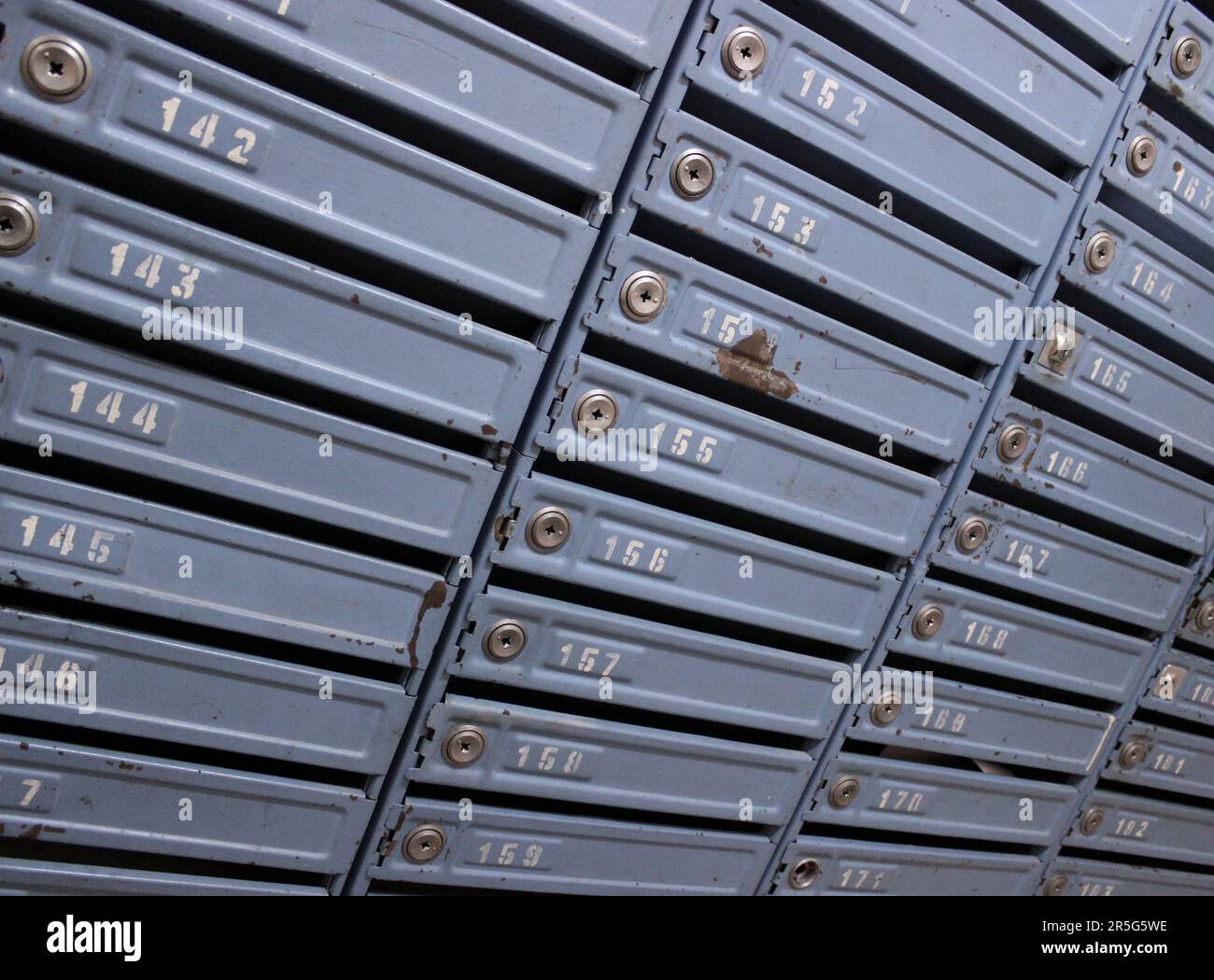 Boîtes de livraison postale rouillées avec numéros d'appartement et mêmes serrures Banque D'Images