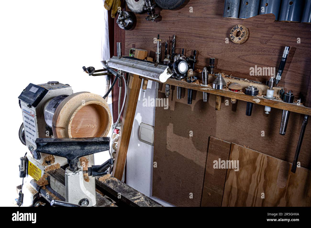 Bol en bois pendant la fabrication dans le tour. Arrière-plan blanc. Banque D'Images