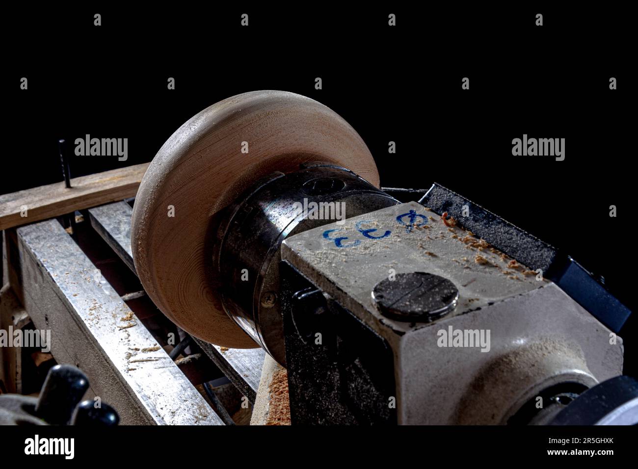 Bol en bois pendant la fabrication dans le tour. Arrière-plan noir. Banque D'Images
