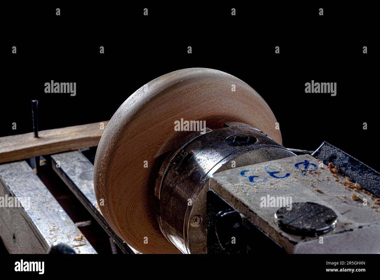 Bol en bois pendant la fabrication dans le tour. Arrière-plan noir. Banque D'Images