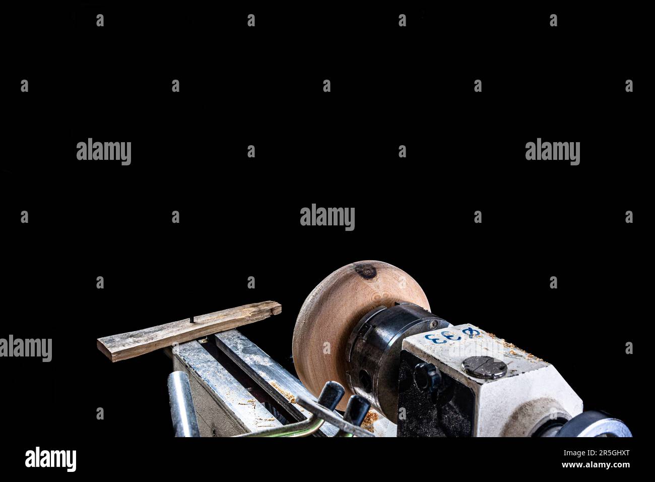 Artisan créant un bol en bois sur le tour. Image dans l'atelier. Arrière-plan blanc. Banque D'Images