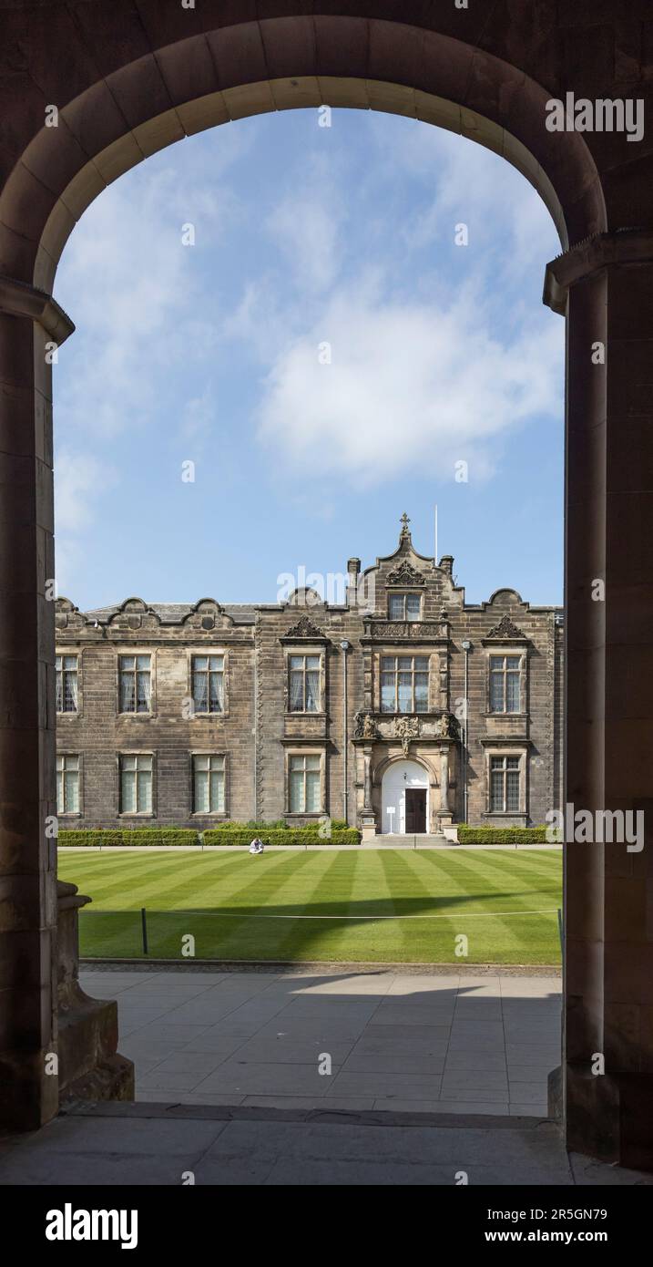Vue à travers une arche de la chapelle Saint-Salvator, Université de St Andrews, Fife, Écosse, de l'autre côté de la pelouse rayée jusqu'à l'entrée de l'aile nord o Banque D'Images