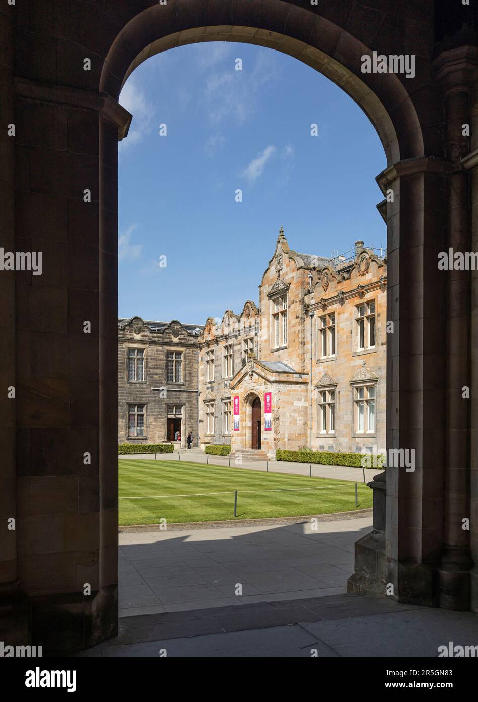 Vue à travers une arche de la chapelle Saint-Salvator, Université de St Andrews, Fife, Écosse, de l'autre côté de la pelouse rayée jusqu'à l'entrée de l'aile ouest de Banque D'Images