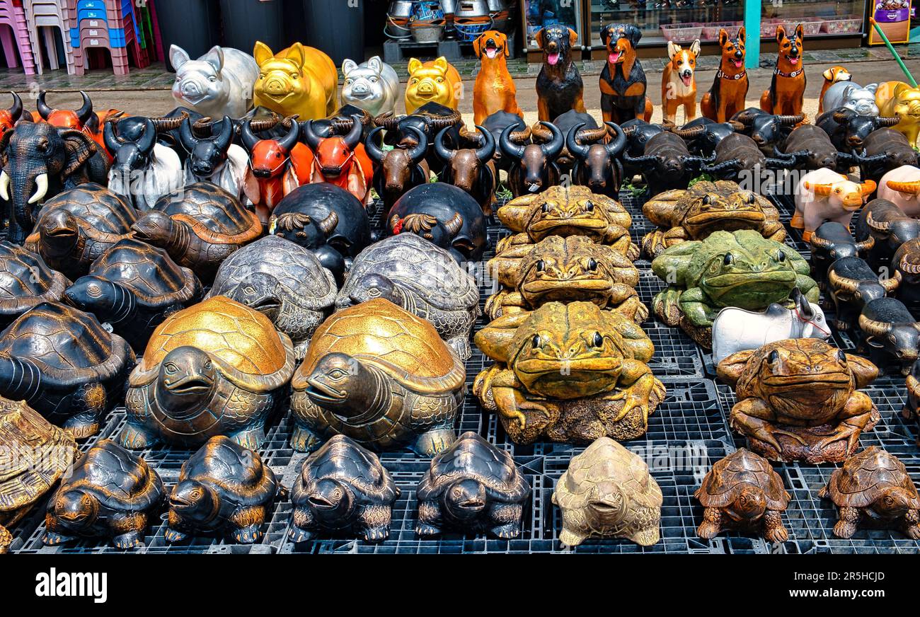 Collection de statues d'animaux thaïlandais colorées à vendre, à utiliser comme ornements de maison et de jardin: Grenouilles, tortues, buffles, porcs et chiens Banque D'Images