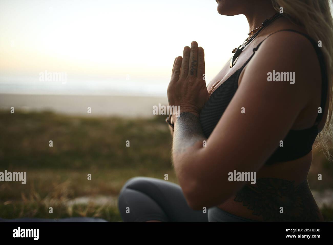 Namaste. une femme méconnaissable assise seule et méditant pendant une journée de détente à l'extérieur. Banque D'Images