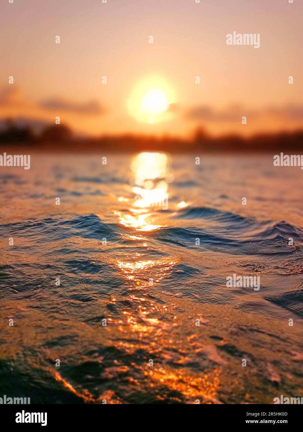 Vagues de mer, coucher de soleil flou arrière-plan bokeh, mer eau surf ondulation texture, lever de soleil flou, île tropicale plage de l'aube, soleil orange coucher de soleil Banque D'Images