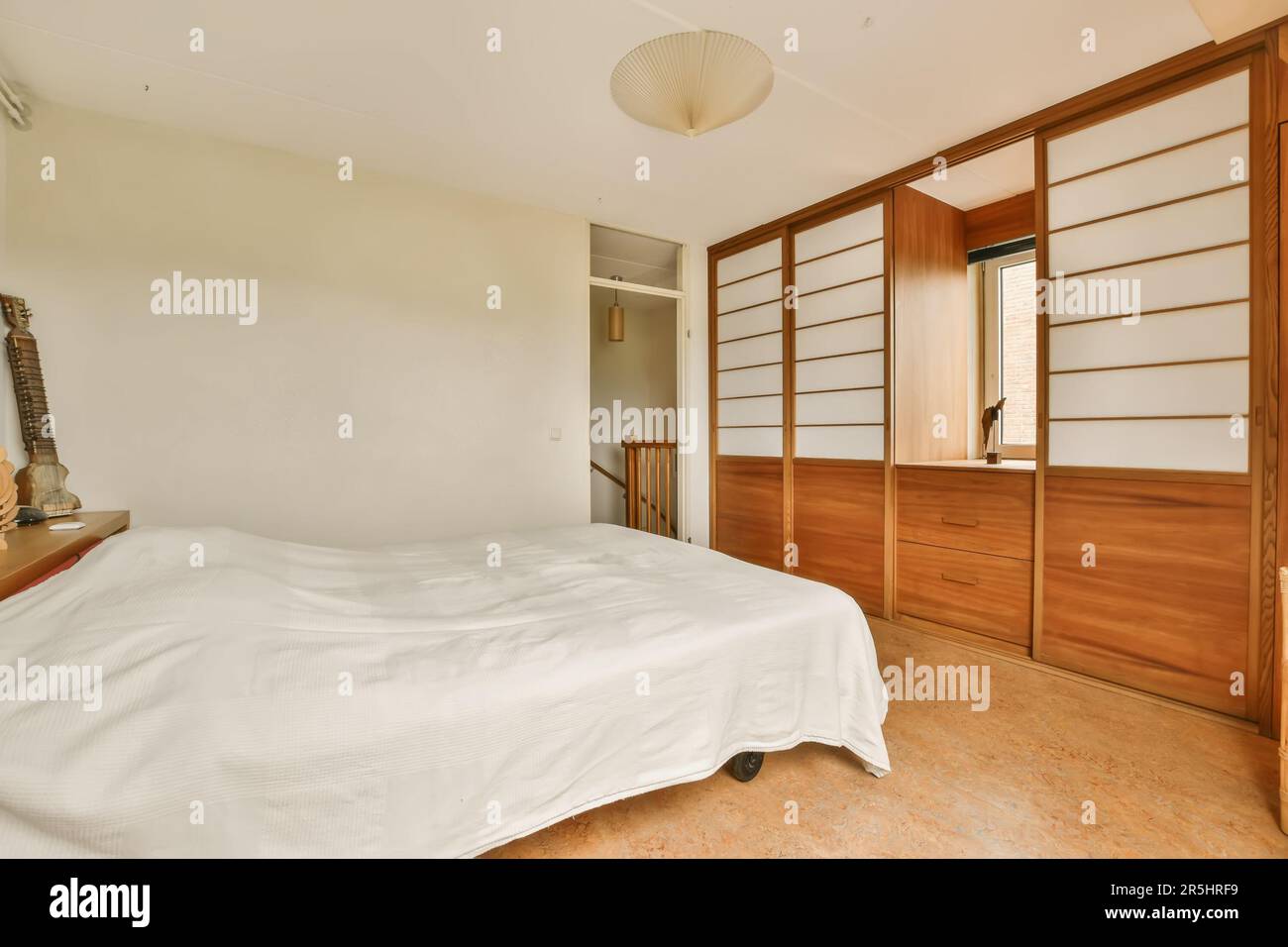 une chambre avec des draps blancs sur le lit et des armoires en bois dans la chambre est très propre, prêt à l'emploi pour les clients Banque D'Images