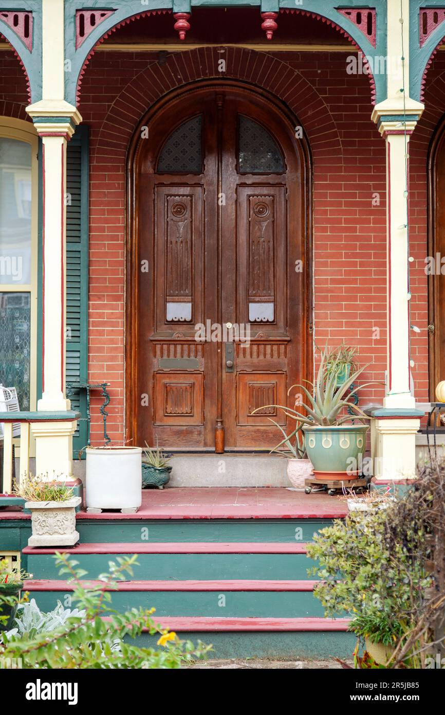 Porte avant en bois et porche de la maison avec plantes Banque D'Images