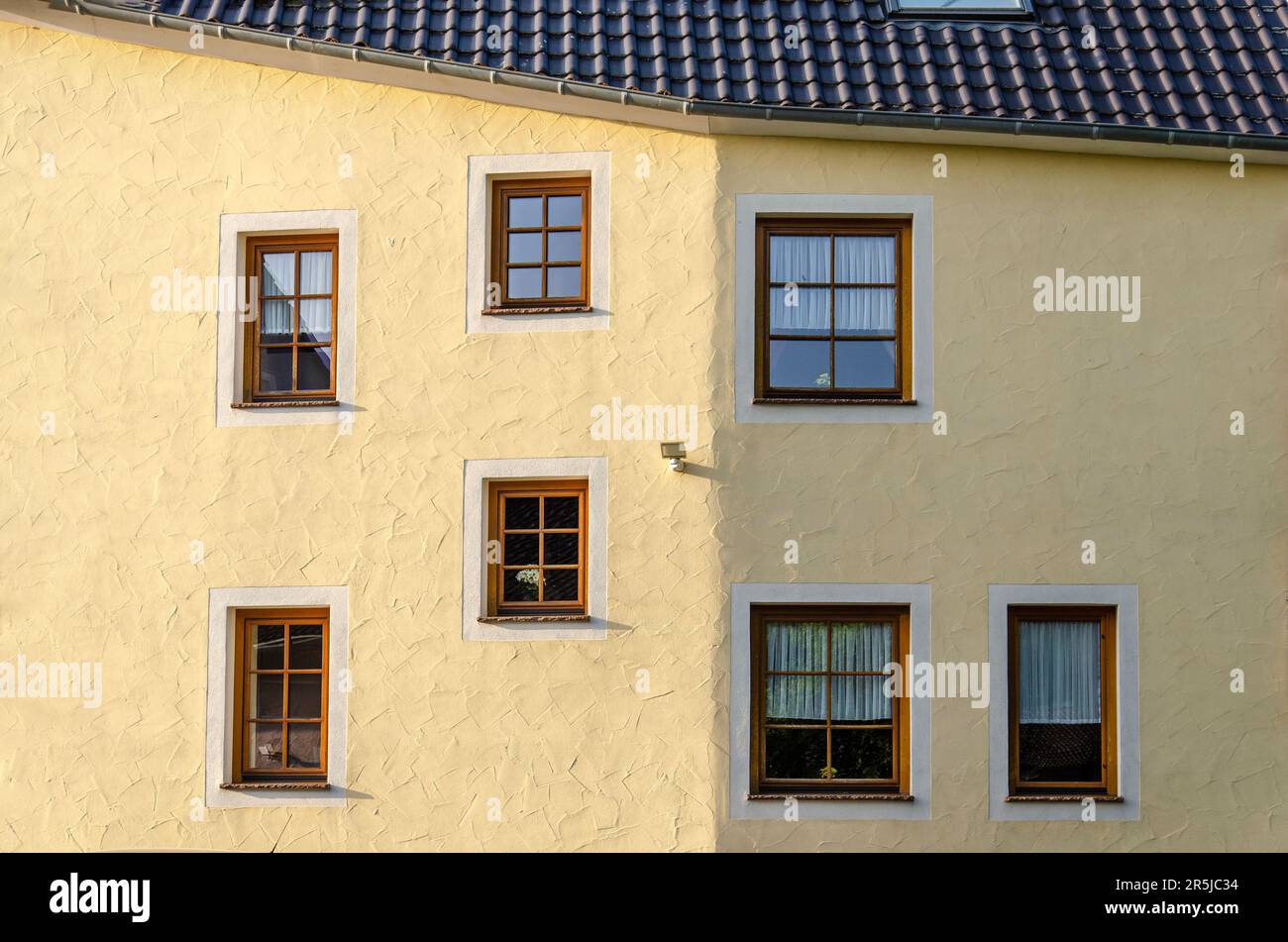 Neroth, Allemagne, 25 mai 2023: Façade en plâtre jaune avec une courbure et apparemment placement aléatoire des fenêtres Banque D'Images