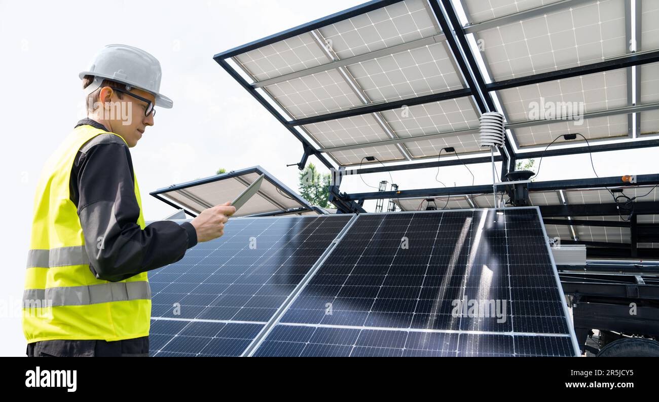 Ingénieur avec un ordinateur tablette sur un fond de station d'énergie solaire mobile Banque D'Images