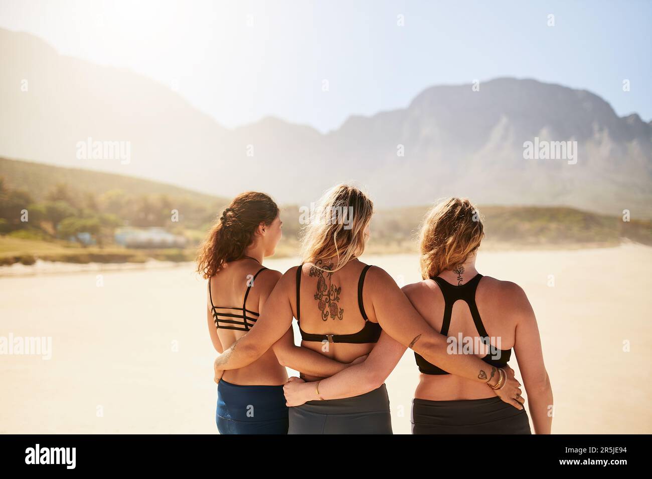Entourez-vous de personnes qui restent calmes. Vue arrière de trois jeunes yogis debout sur la plage. Banque D'Images