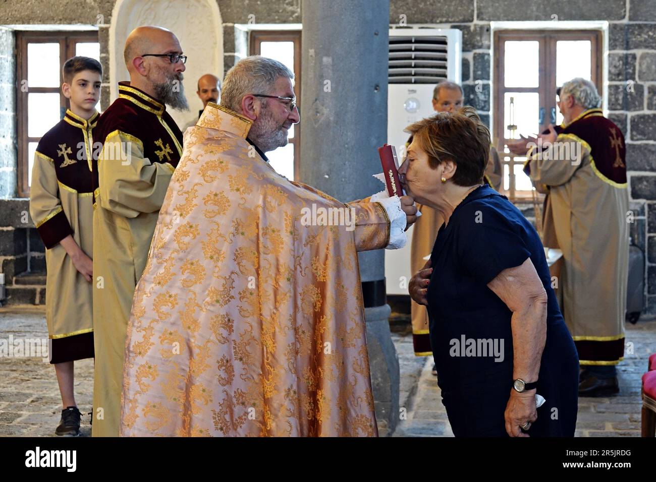 Une femme embrasse une Bible entre les mains du prêtre aîné Abraham Firat après le rituel de l'église de Diyarbak?r Surp Hovsep. À l'église catholique arménienne Surp Hovsep, Qui a été lourdement endommagé par les affrontements entre les militants armés du PKK kurde et les forces de sécurité turques dans le centre de Diyarbakir en 2015 et réparé à la suite d'une restauration de 4 ans, le deuxième rituel des 100 dernières années après le premier rituel de 2021. Très peu d'Arméniens venus d'Istanbul et qui vivaient à Diyarbakir ont assisté à la cérémonie. Le rituel était dirigé par le prêtre principal Abraham Firat et le subordonné Deacon Jan Acemoglu, wh Banque D'Images