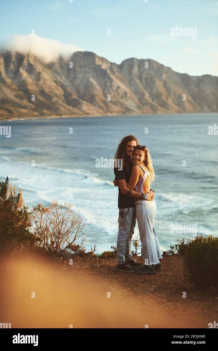 Il signifie tout pour moi. Photo en longueur d'un jeune couple affectueux qui se tient debout ensemble et qui s'embrasse sur le flanc de la montagne près de la mer. Banque D'Images