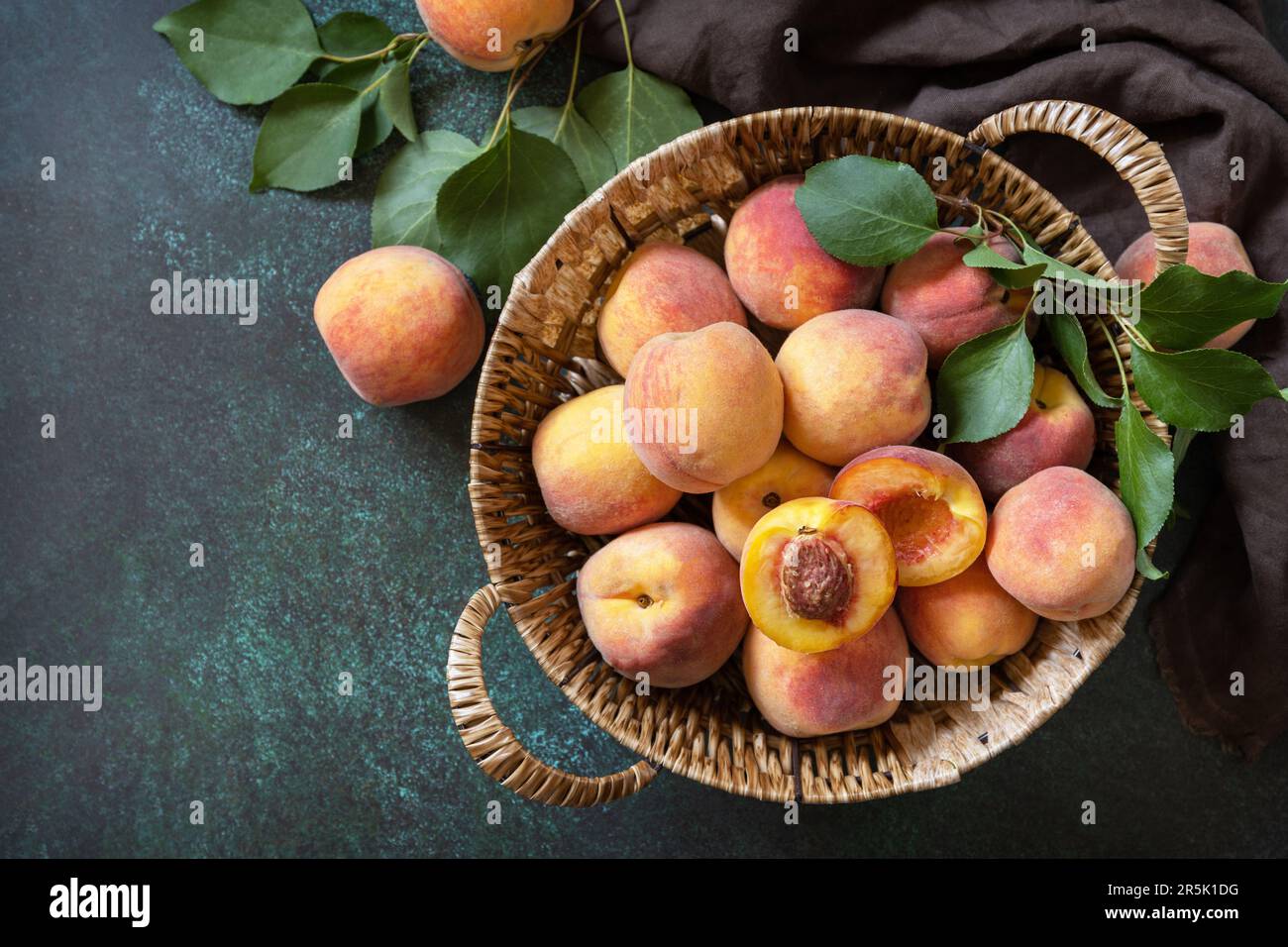 Arrière-plan de la récolte. Fruits biologiques. Marché agricole. Panier de pêches mûres sur une table en pierre. Vue de dessus. Banque D'Images
