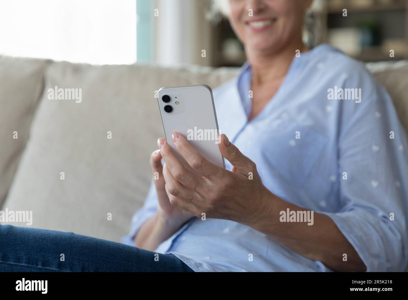 Gros plan du smartphone blanc dans les mains de femmes matures Banque D'Images