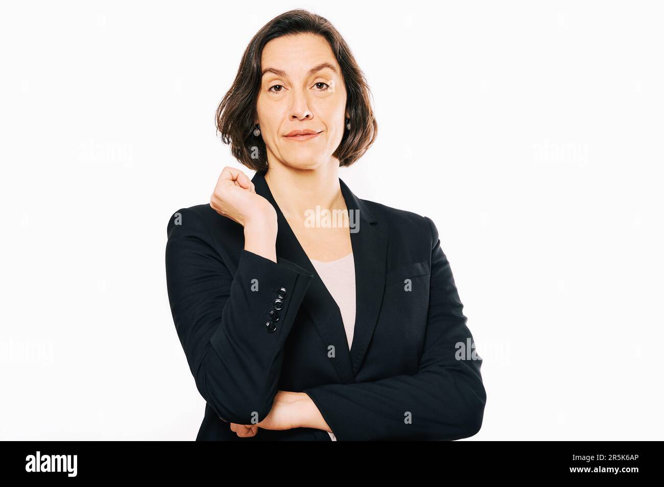 Studio portrait de femme de 45 - 50 ans posant sur fond blanc, portant une veste noire Banque D'Images