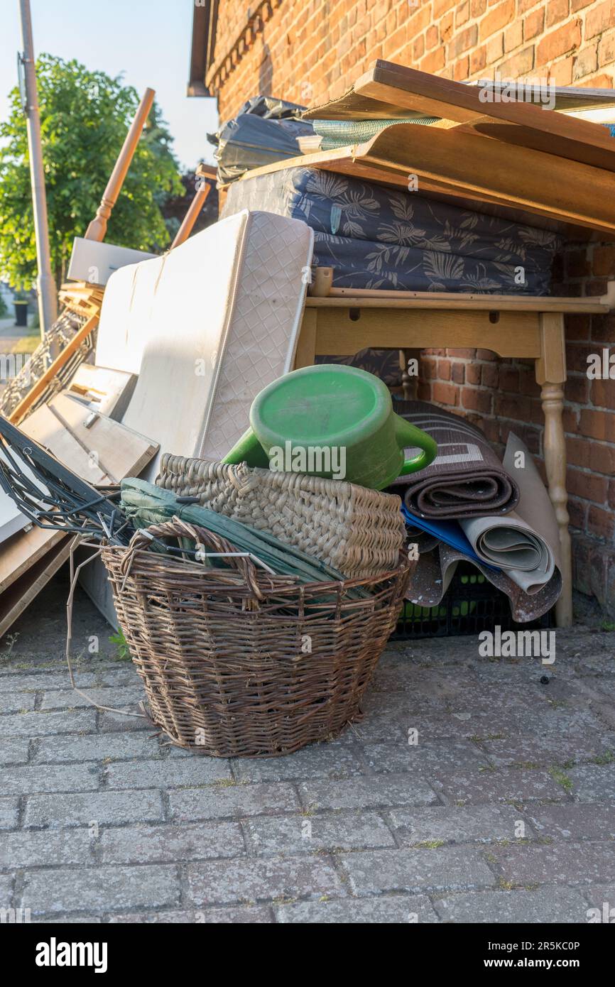 Tas de déchets volumineux avec matelas, cadre de lit, table et placards au bord de la route Banque D'Images