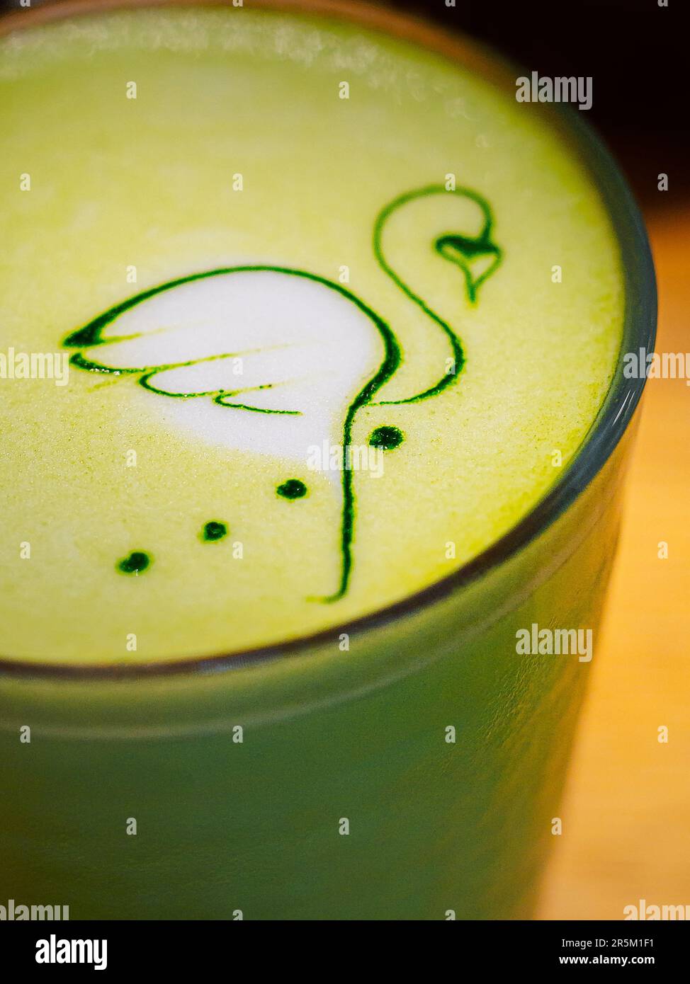 Latte art - dessin de flamants roses sur mousse avec du thé matcha chaud sur le lait de coco. Banque D'Images