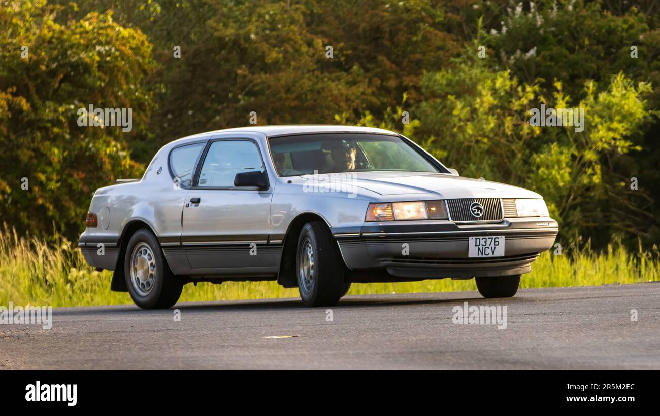 Stony Stratford, Royaume-Uni - 4 juin 2023: 1987 FORD MERCURY COUGAR voiture classique voyageant sur une route de campagne anglaise. Banque D'Images