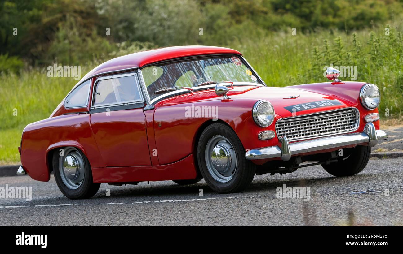 Stony Stratford, Royaume-Uni - 4 juin 2023: 1963 rouge AUSTIN HEALEY SPRITE voiture classique voyageant sur une route de campagne anglaise. Banque D'Images