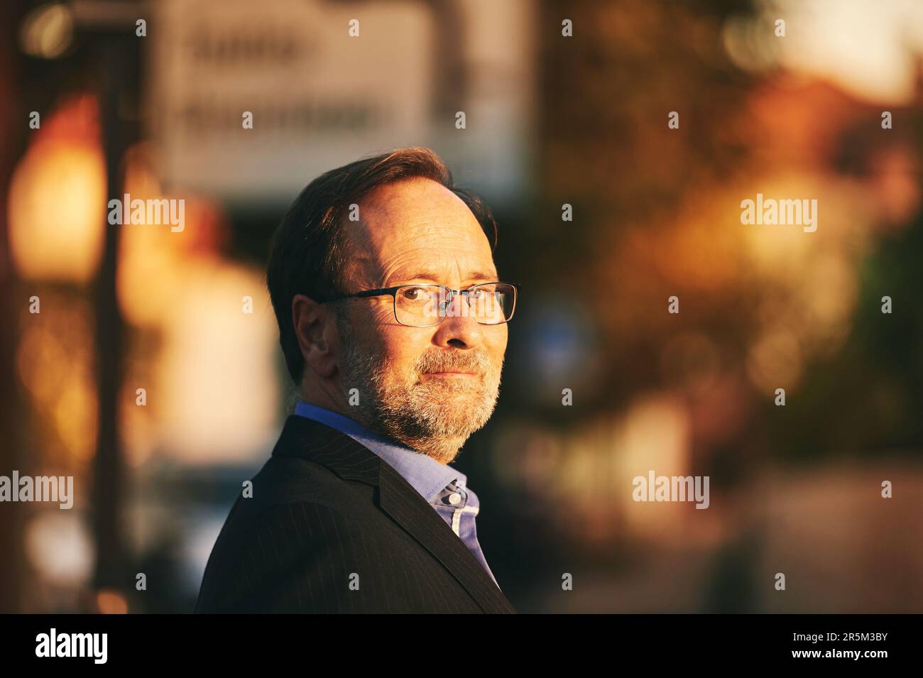 Portrait extérieur d'un homme d'âge moyen portant un costume et des lunettes Banque D'Images