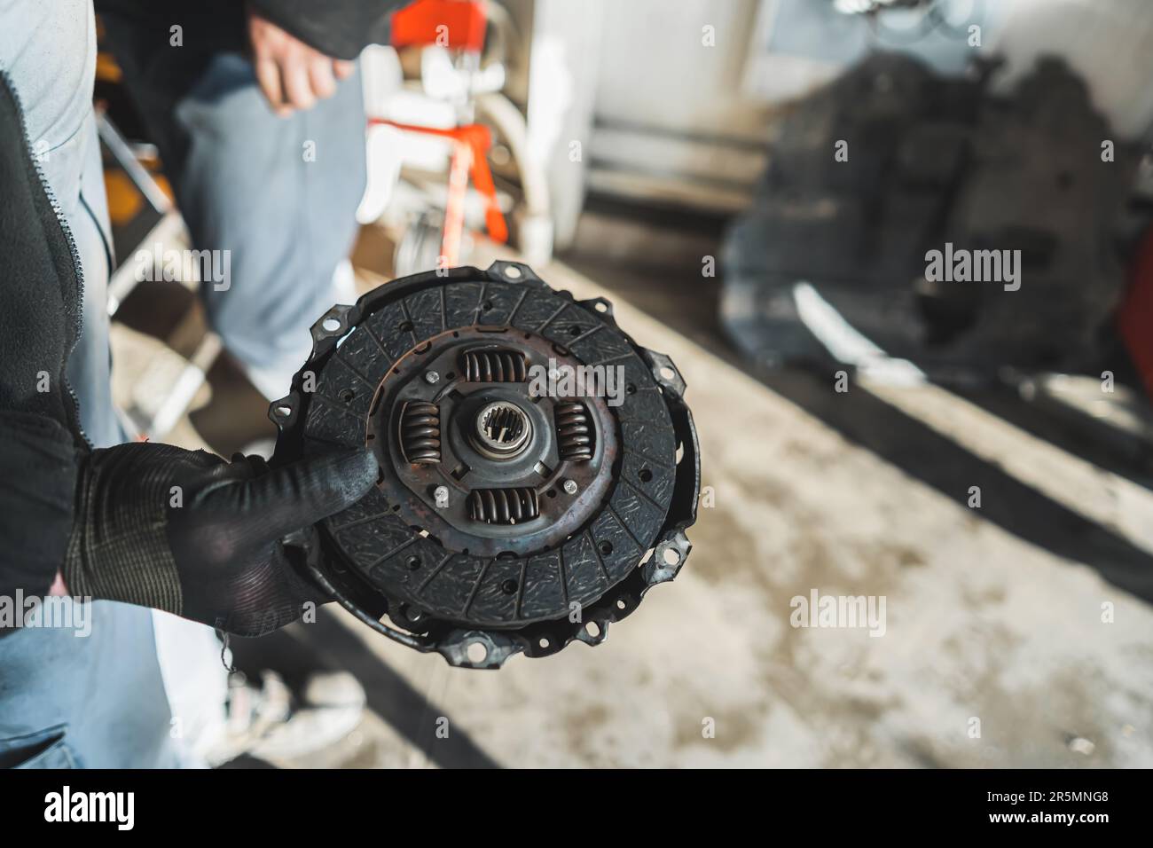 Mains de mécanicien tenant un ancien embrayage cassé à l'atelier de  réparation automobile. Photo de haute qualité Photo Stock - Alamy