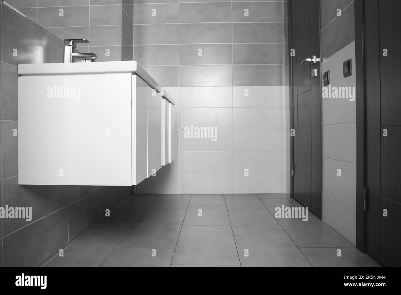 Beaux lavabos propres près du miroir dans les toilettes publiques Banque D'Images