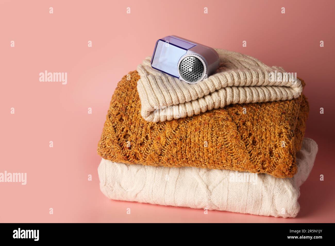Rasoir en tissu moderne et vêtements tricotés sur fond rose, espace pour le  texte Photo Stock - Alamy