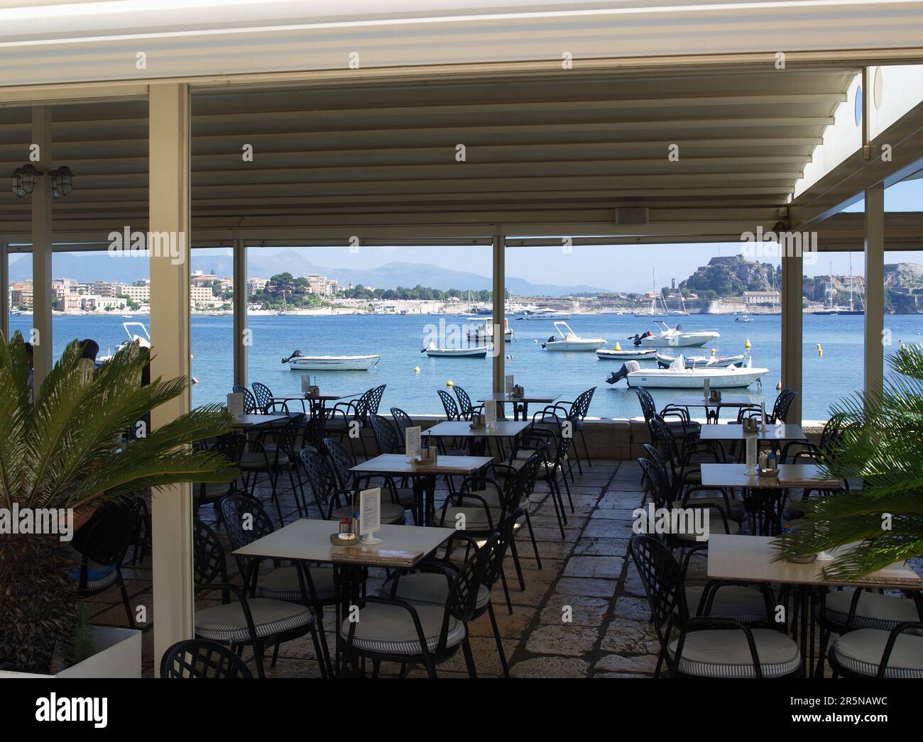 Tables vides au Nautilus Cafe Restaurant, Garitsa Bay, Corfu Town, Grèce Banque D'Images