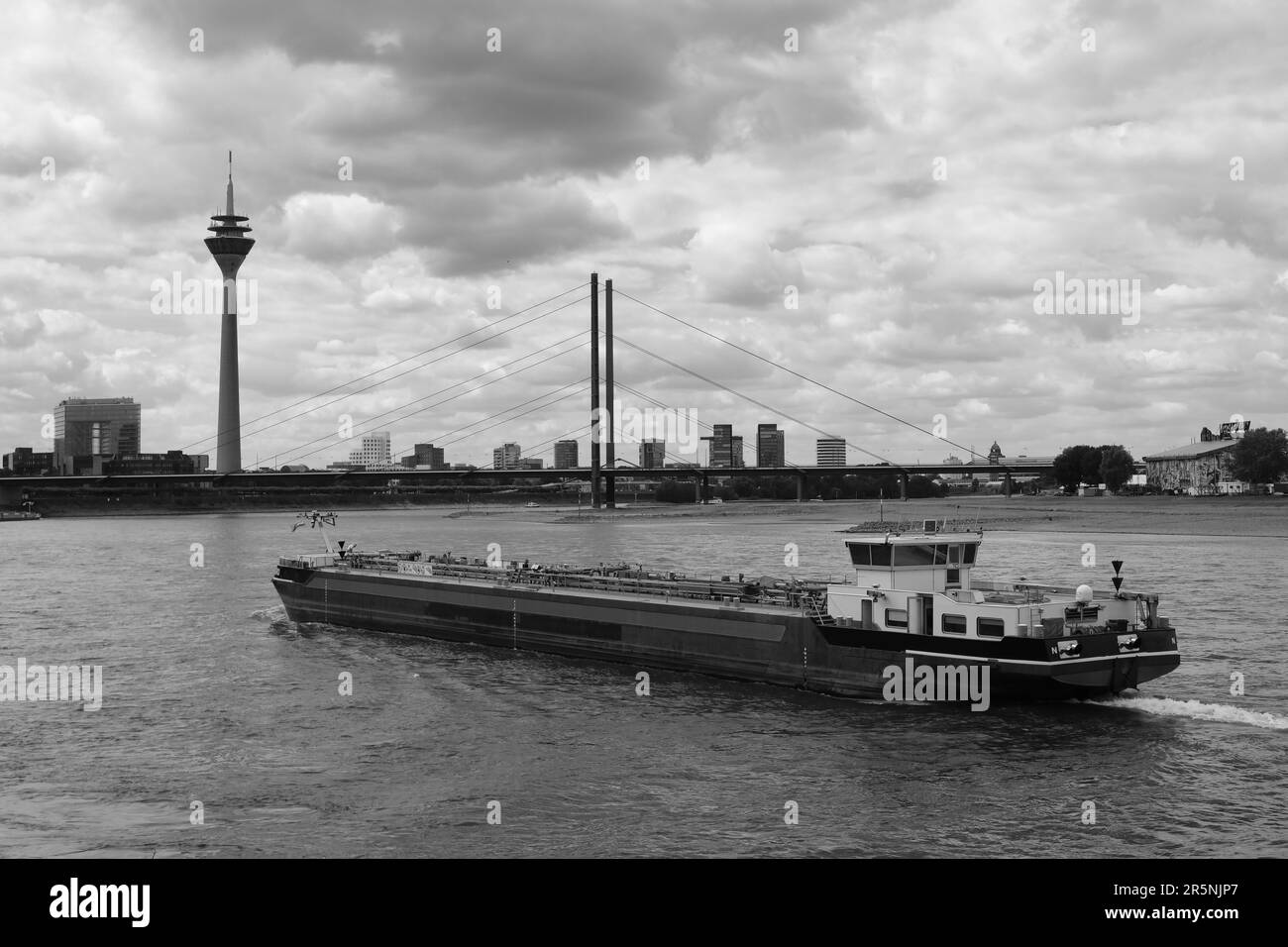 Vue sur le Rhin avec cargo, derrière la tour de télévision, Düsseldorf, Allemagne Banque D'Images