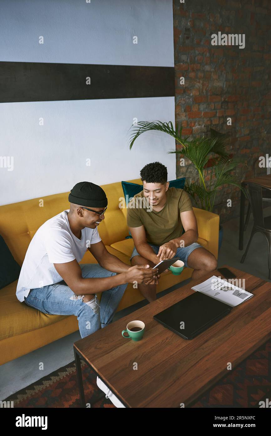 Nous proposons les meilleures idées que le café. deux jeunes hommes utilisant une tablette numérique tout en étant assis dans un café. Banque D'Images