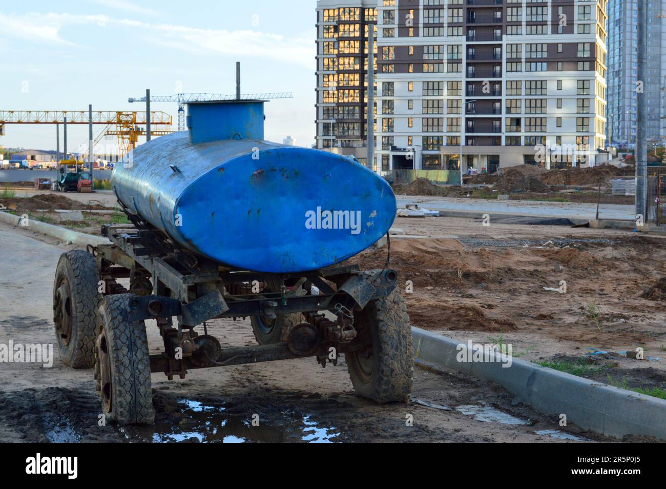 station mobile de distribution d'eau dans le centre-ville. une grande voiture bleue sur roues avec un réservoir plein d'eau la livre aux gens dans des bouteilles et des conteneurs. Banque D'Images