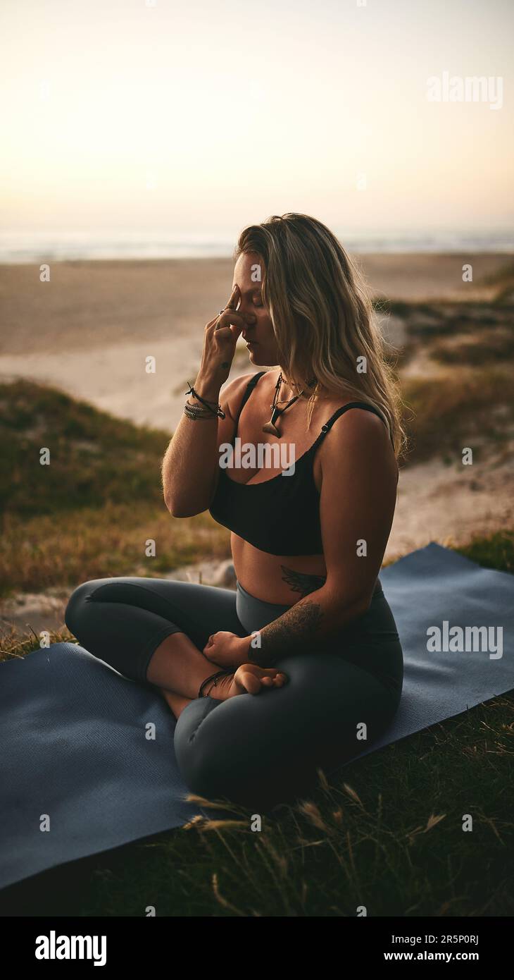 Respirer à travers le processus. Prise de vue en longueur d'un jeune yogi attrayant assis seul et mettant la pression sur le troisième point de pression oculaire. Banque D'Images