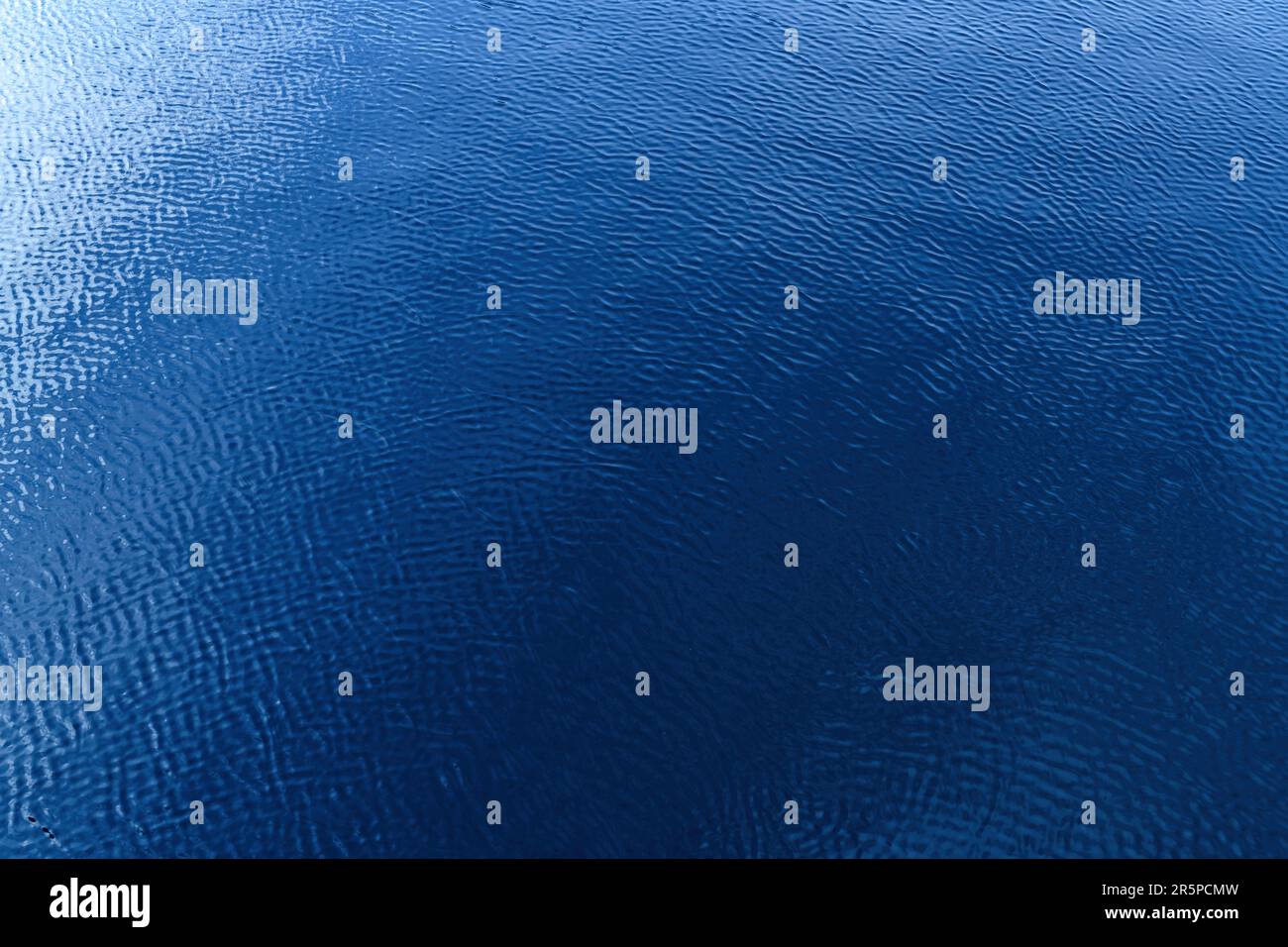 Surface d'eau bleue avec ondulations et réflexion de lumière. Texture d'eau douce propre de la rivière Nissan dans la ville de Halmstad en Suède. Mise au point sélective Banque D'Images